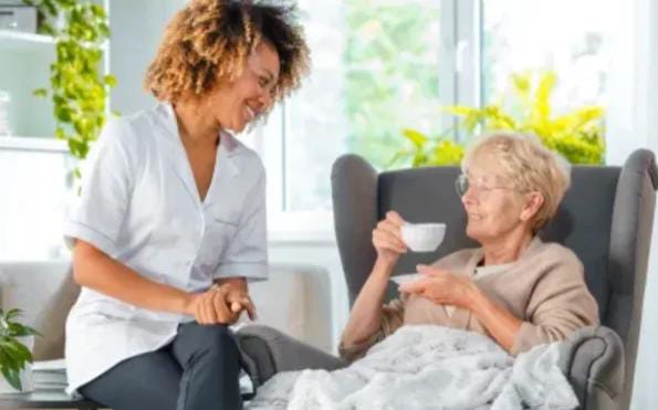Care professional supporting an older woman at home